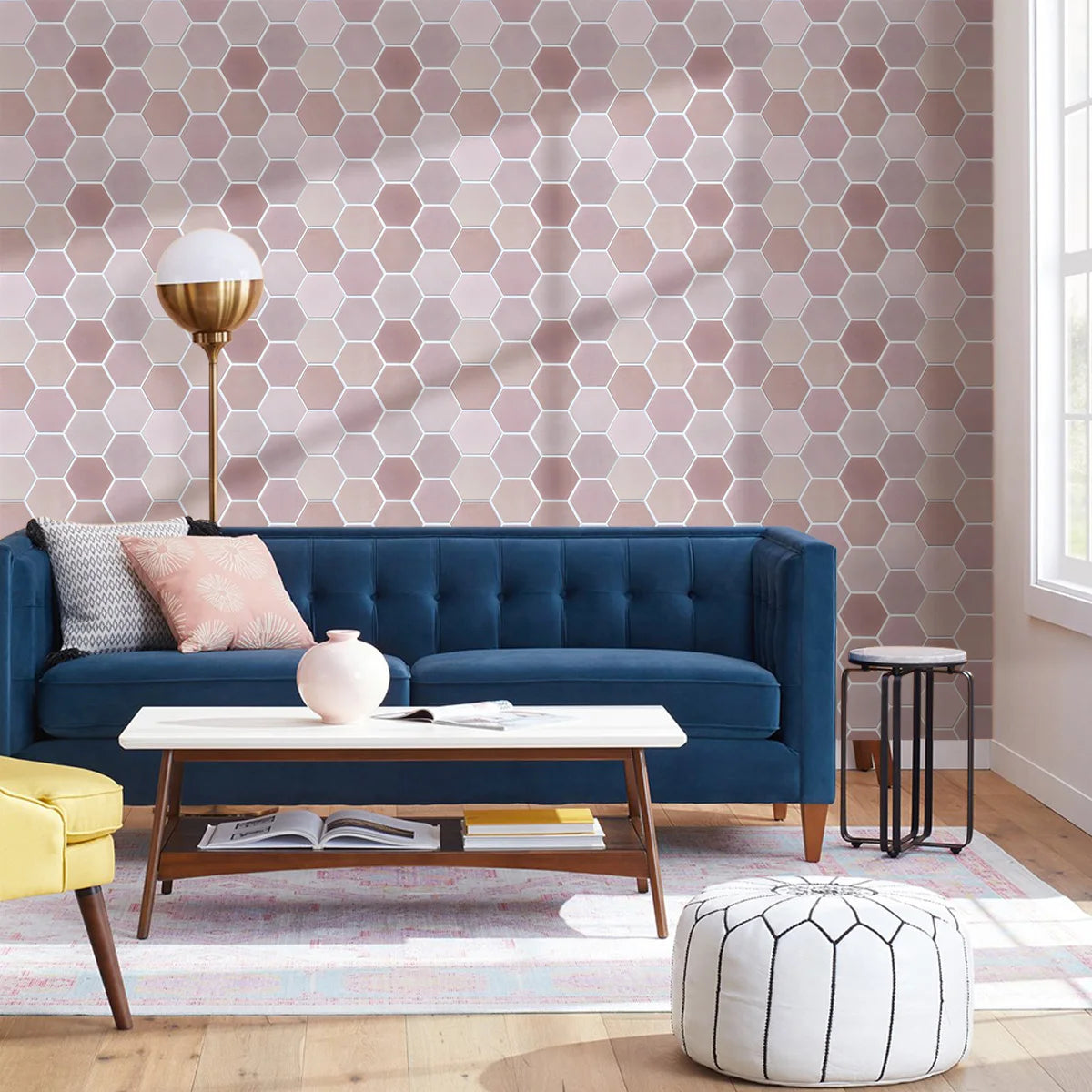 Woonkamer met een muur bekleed met roze zeshoeken en een blauwe bank