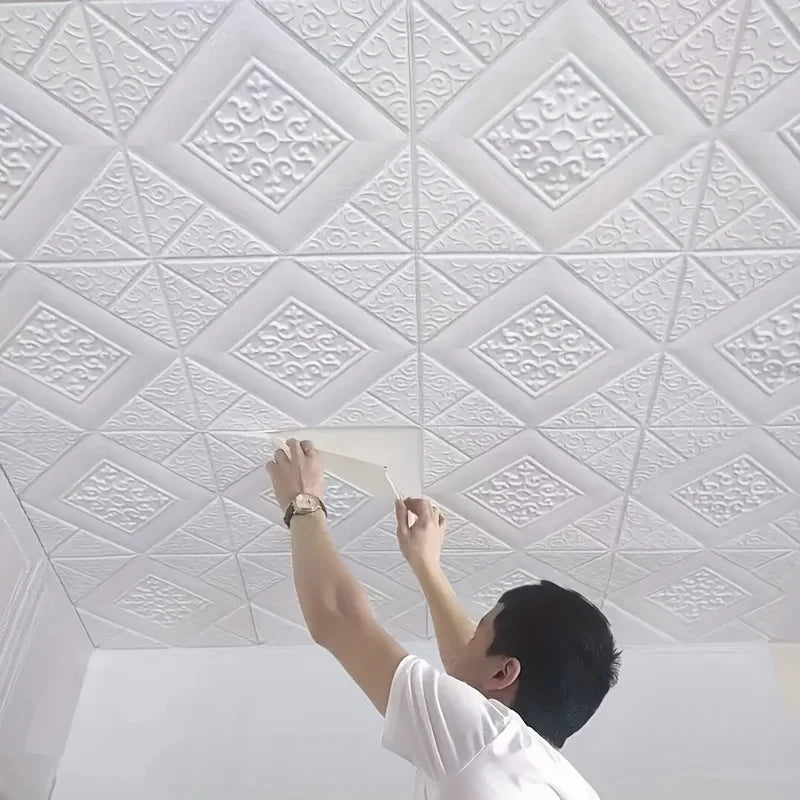 Zelfklevende witte 3D panelen aanbrengen op het plafond van een kamer