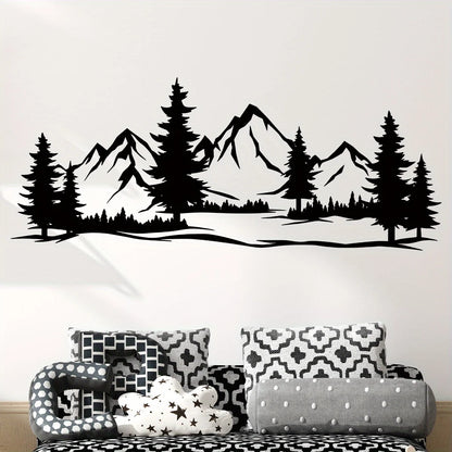Black mountain and pine silhouette above a sofa with black and white patterned cushions
