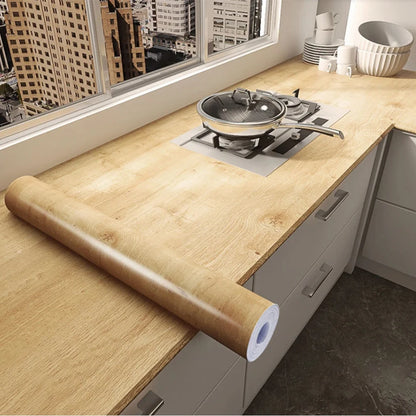 Roll of golden wood effect vinyl wrap on a kitchen worktop, Model 5