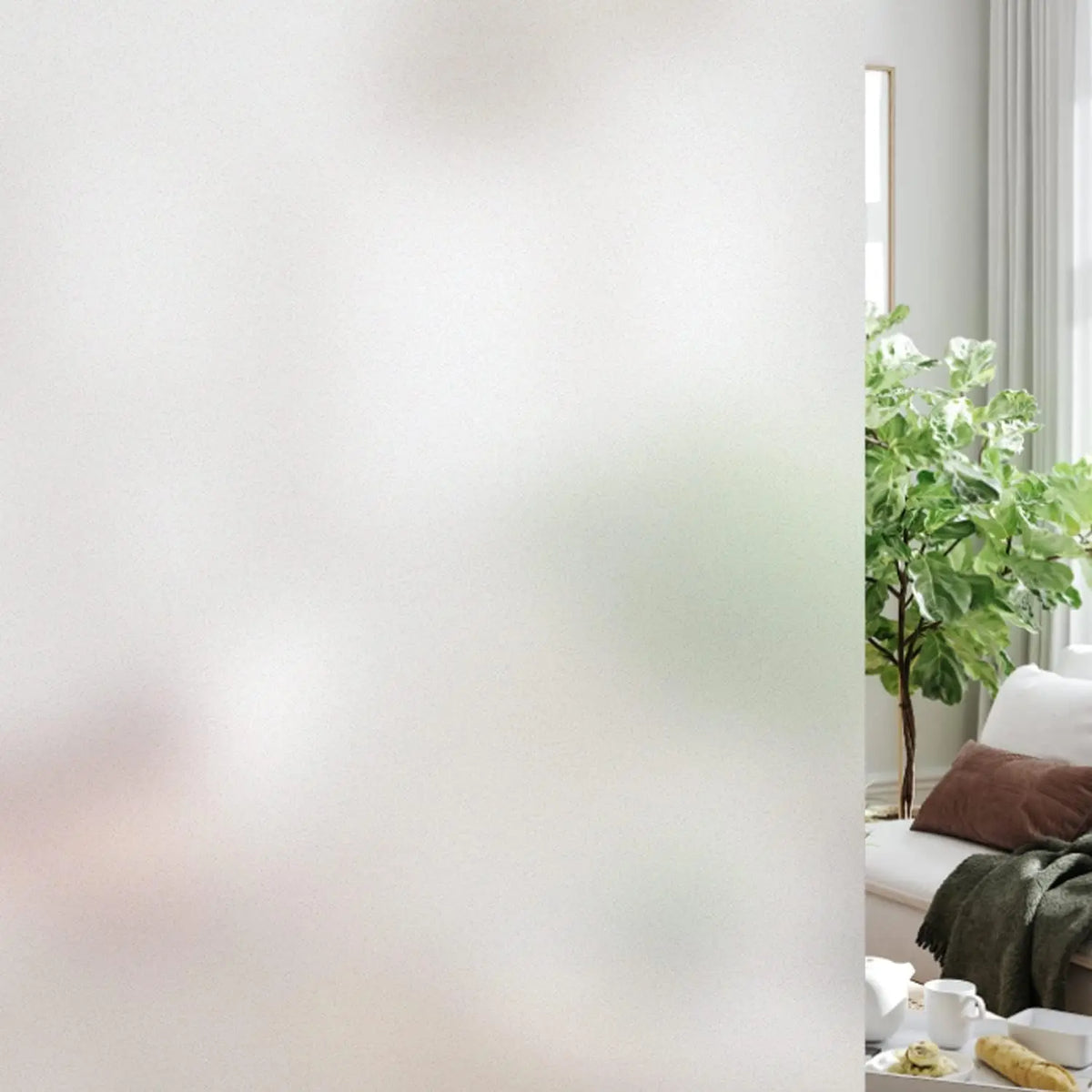 Glas van een raam bedekt met raamfolie met matglaslook, met een vage kamer erachter