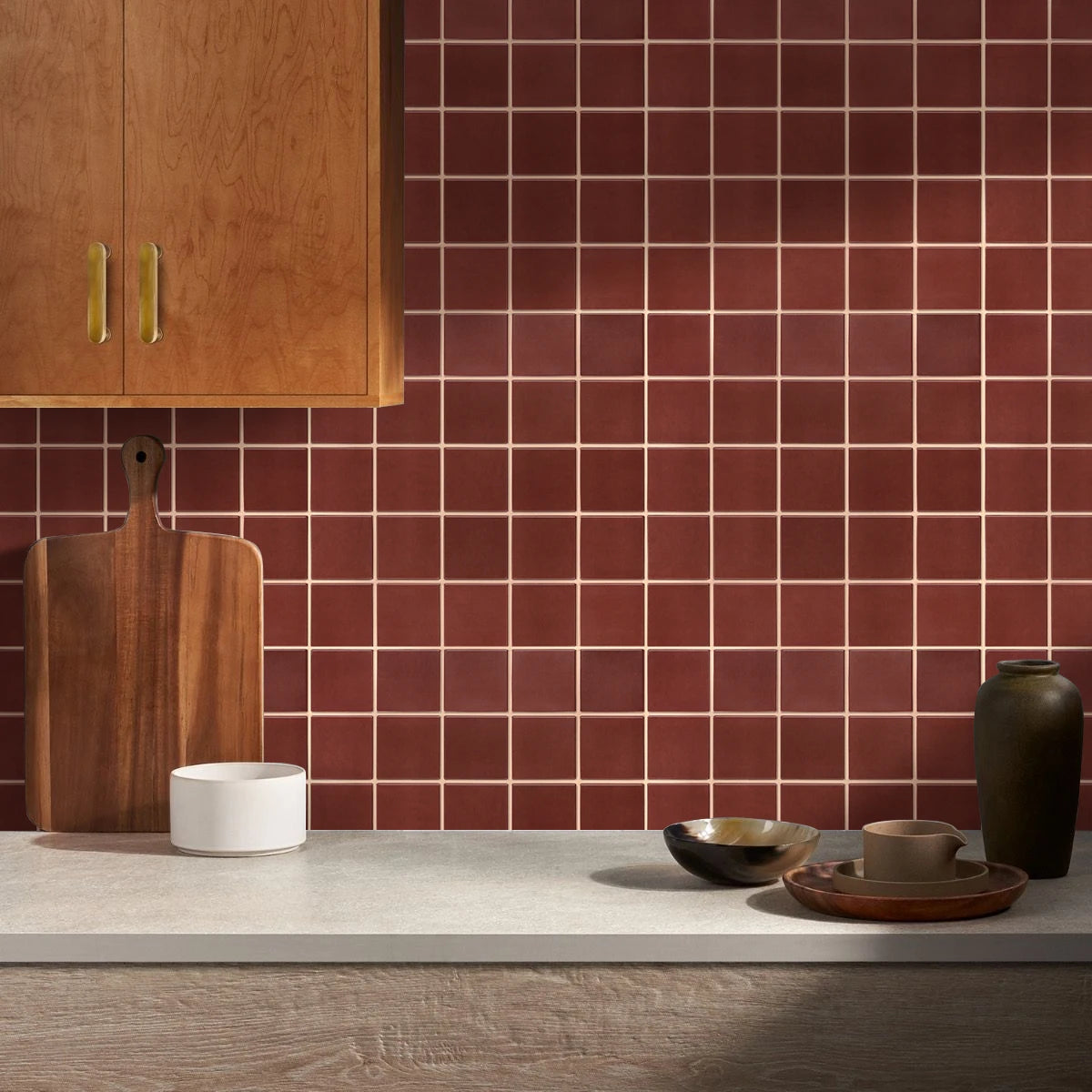 Kitchen splashback covered in red self-adhesive square panels, beside a wooden cabinet