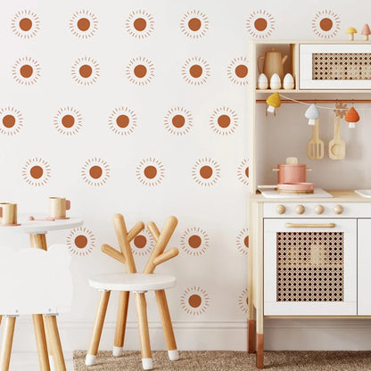 White wall with orange sun stickers next to a toy kitchen and a stool