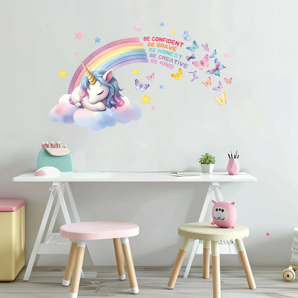 Muur boven een bureau met roze krukken en de muursticker met eenhoorn en regenboog