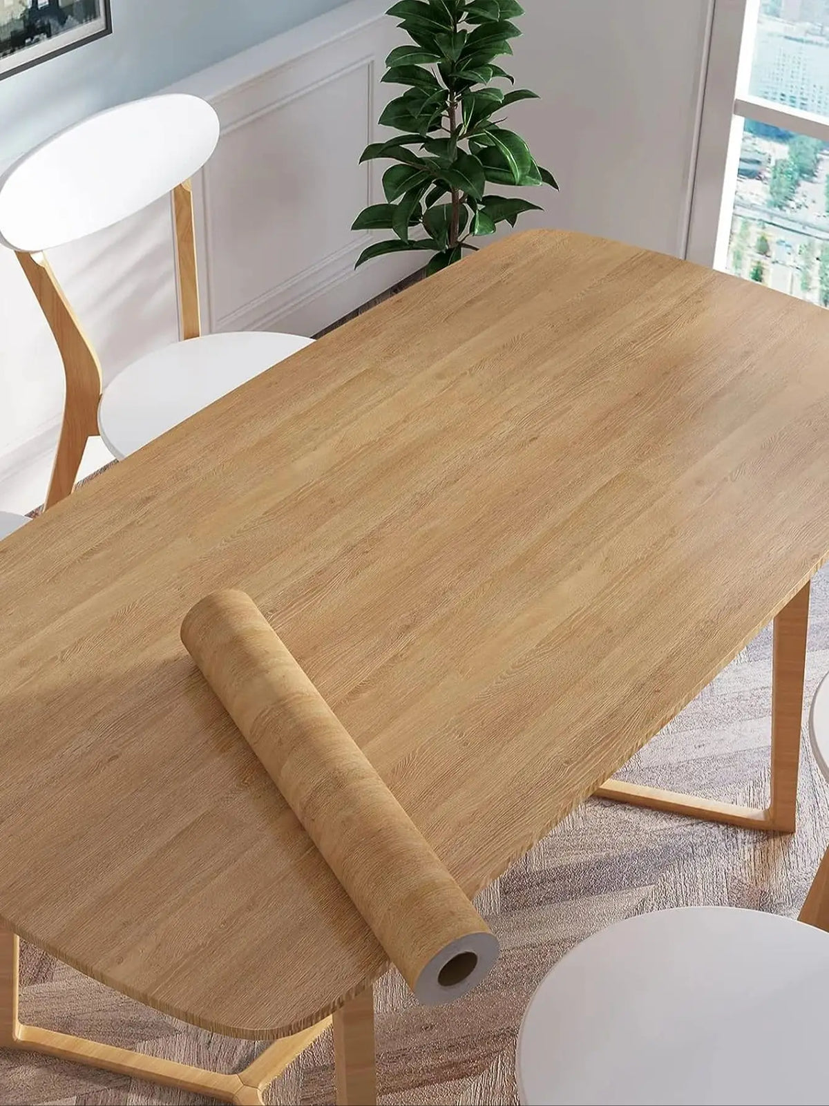Tisch in heller Holztönung mit einer Rolle Klebefolie in Holzoptik darauf