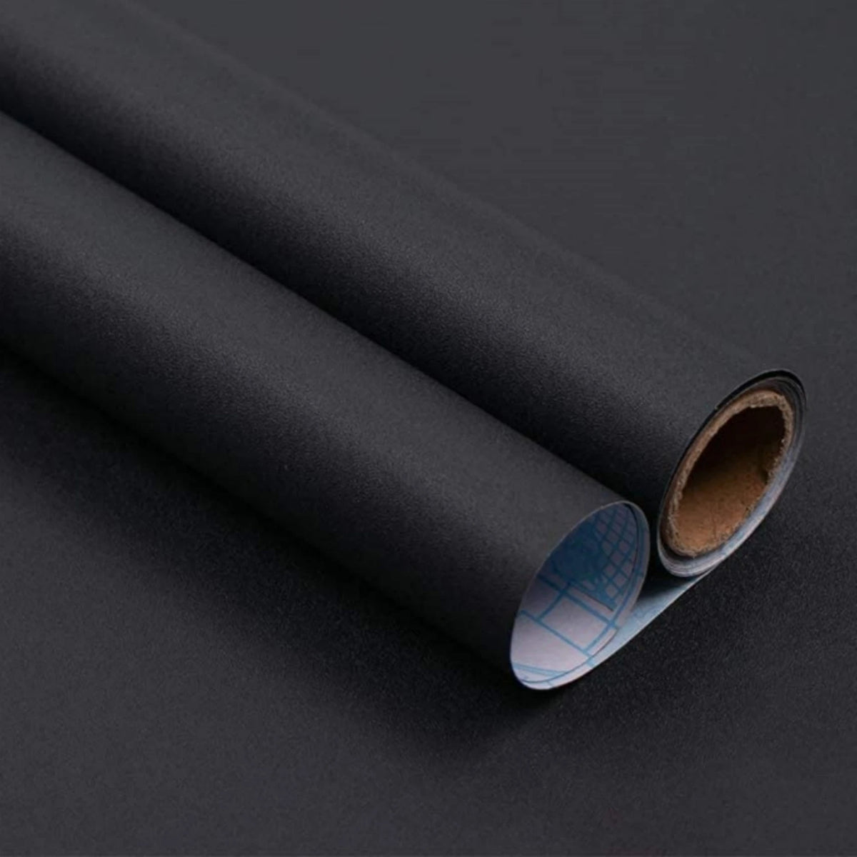 Nahaufnahme einer Rolle matte schwarze selbstklebende Folie mit dem Schutzpapier am Ende
