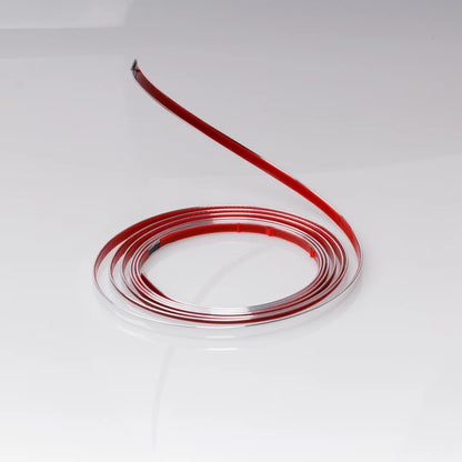 Glänzende silberfarbene flexible selbstklebende Leiste abgerollt, rotes doppelseitiges Klebeband, weißer Hintergrund