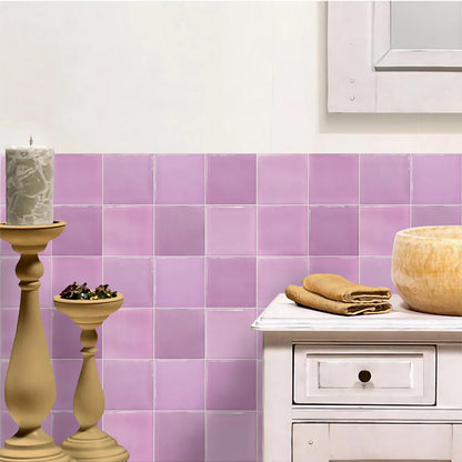 White cabinet and candlesticks in front of a wall of lilac gradient tile stickers