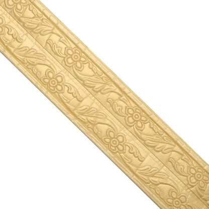 Goldene selbstklebende Zierleiste mit Blumenrelief auf weißem Hintergrund