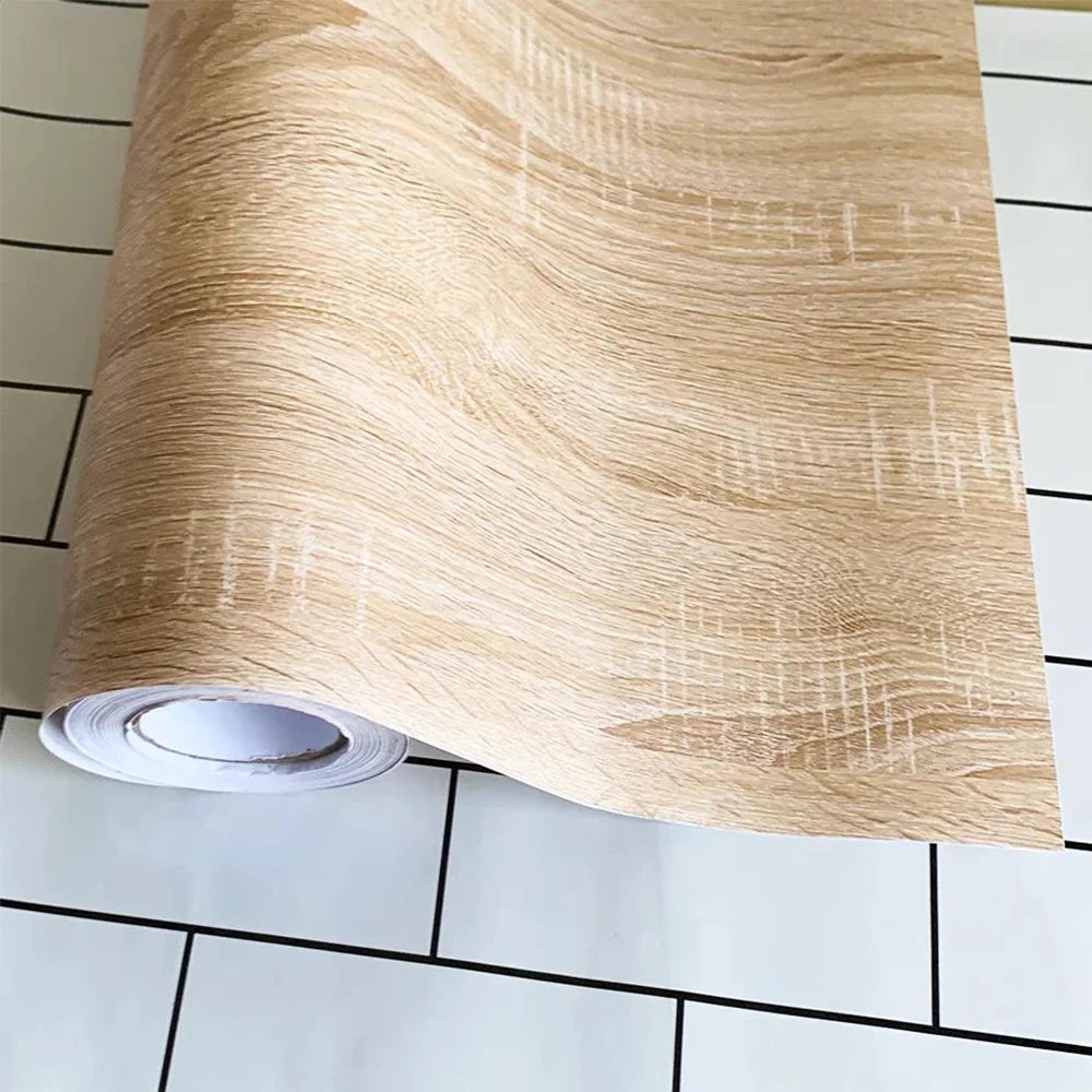 Rolle Klebefolie in hellem Beige in Holzoptik, teilweise abgerollt, auf weißem Hintergrund