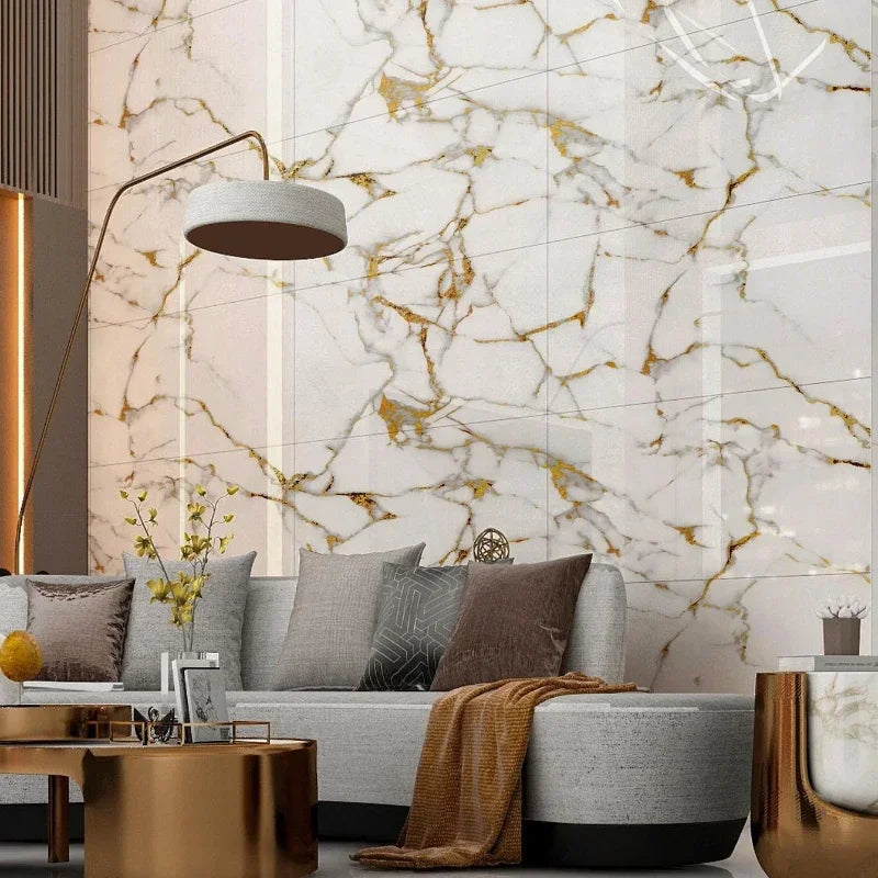Wohnzimmer mit einer Wand aus weißen und goldfarbenen selbstklebenden Fliesen in Marmoroptik