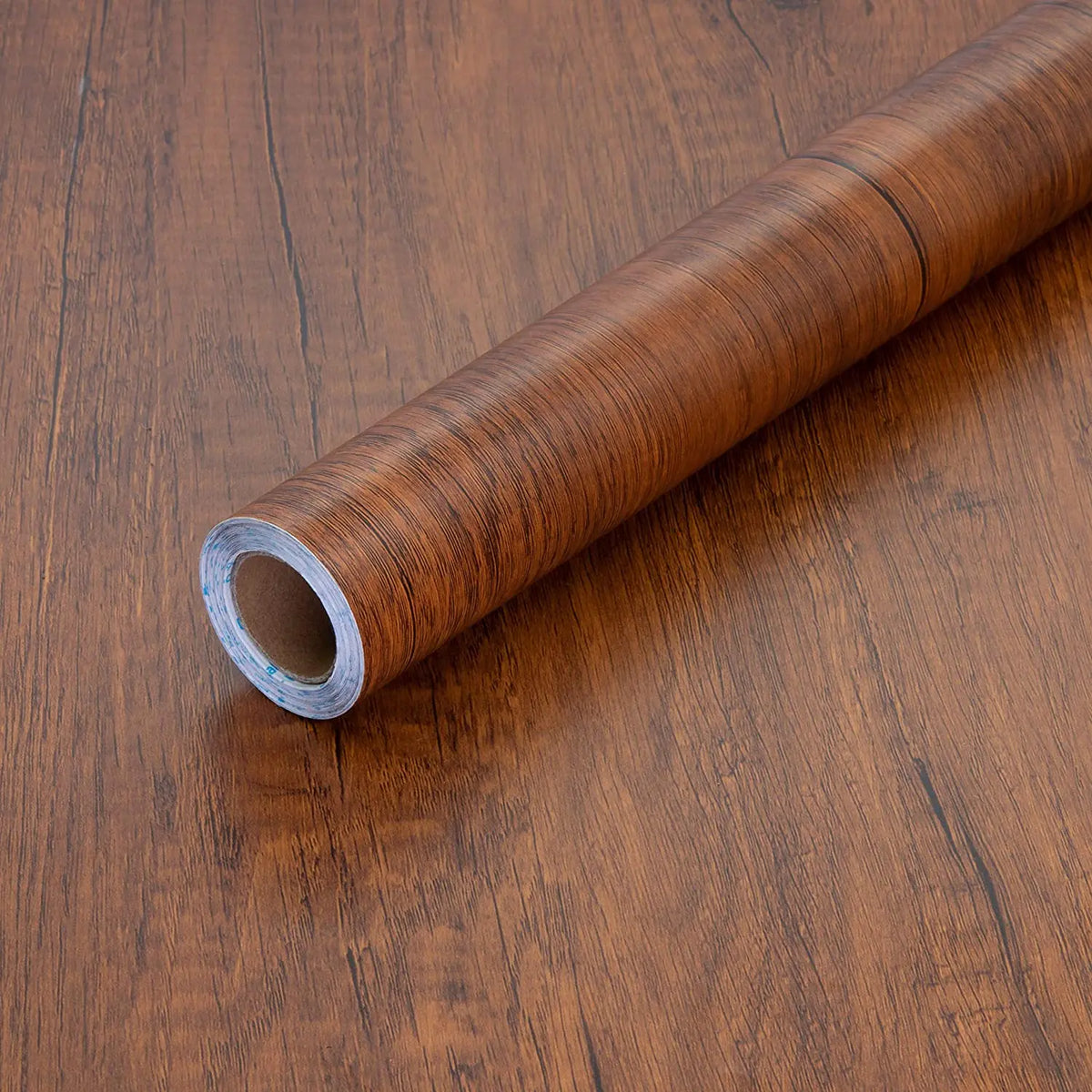 Roll of brown wood effect vinyl wrap with dark grain, on a wood base