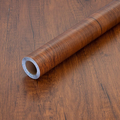 Roll of brown wood effect vinyl wrap with dark grain, on a wood base