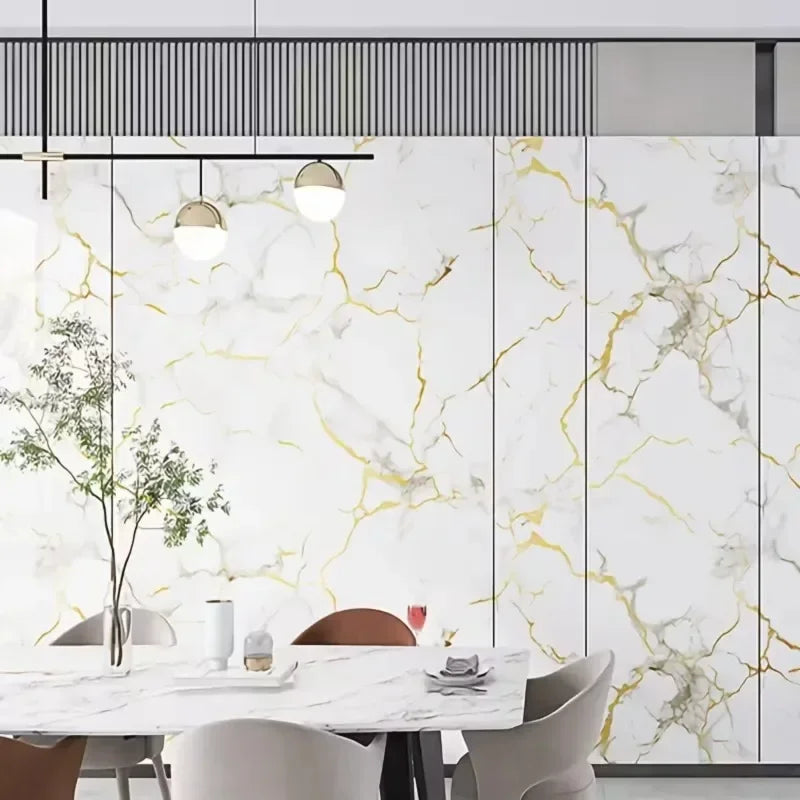 Dining room with a wall covered in white marble effect panels with golden and grey veins