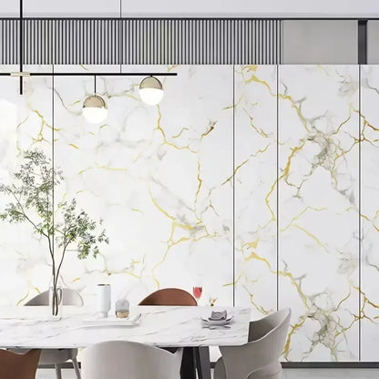 Dining room with a wall covered in white marble effect panels with golden and grey veins