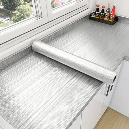 Worktop by a window with a roll of stainless steel effect vinyl