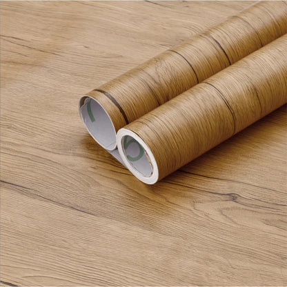 Two rolls of caramel brown wood effect vinyl wrap, Model 3, on a wood background