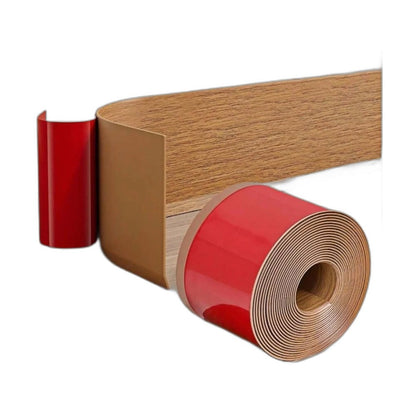 Rolle selbstklebende Sockelleiste in gelber Eichenoptik mit roter Folie, Streifen über Holzboden abgerollt