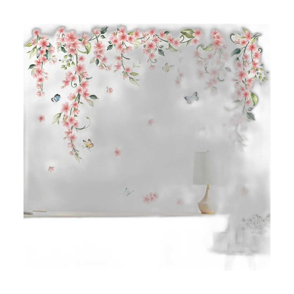 Roze klimbloemen-stickers met vlinders op een witte muur boven een laag kastje met een lamp
