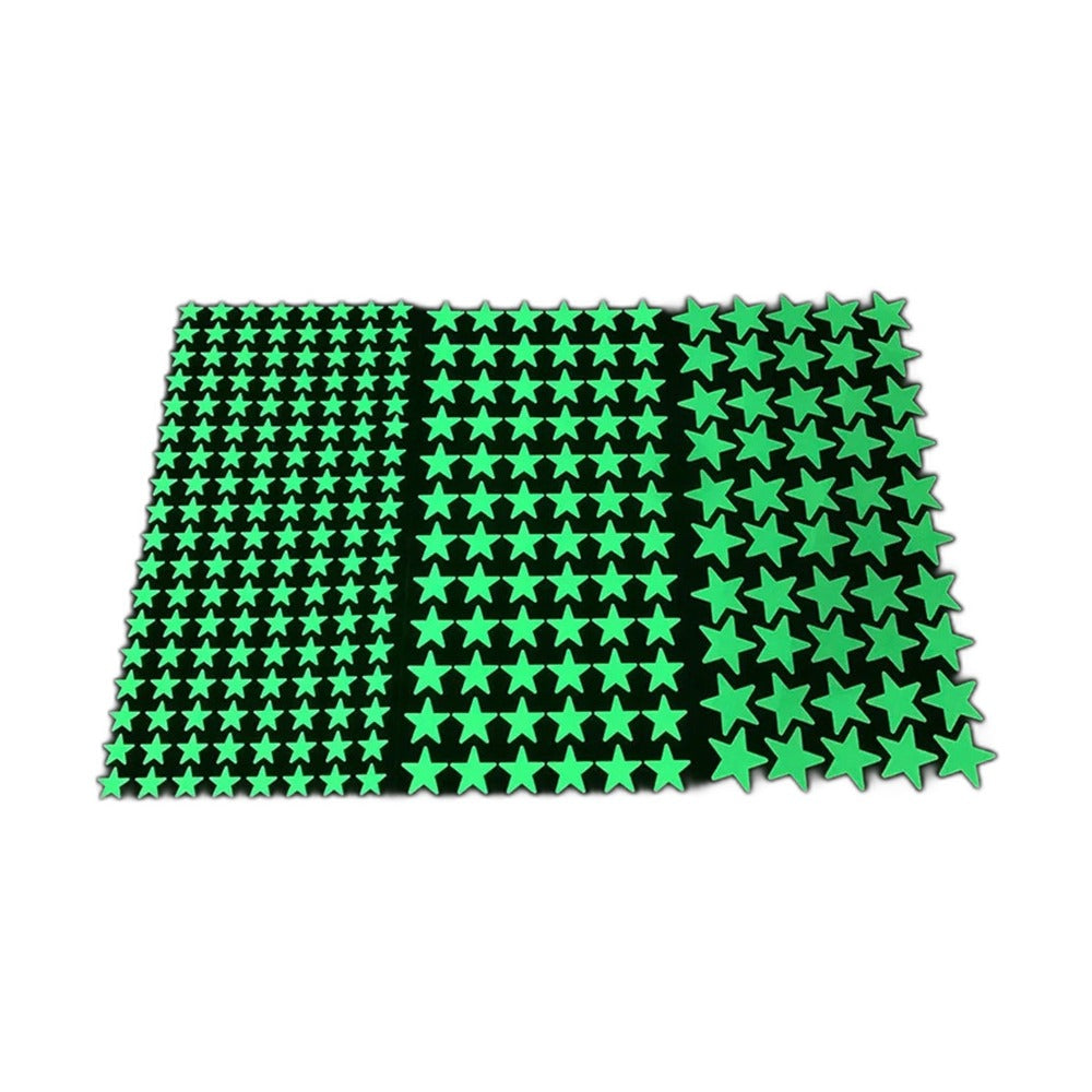 Three sheets of glow in the dark adhesive stars in different sizes on a black background
